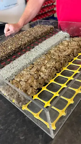 A cutaway sample showing the build up of a resin driveway: the open grid base at the bottom, then the aggregate bound above it