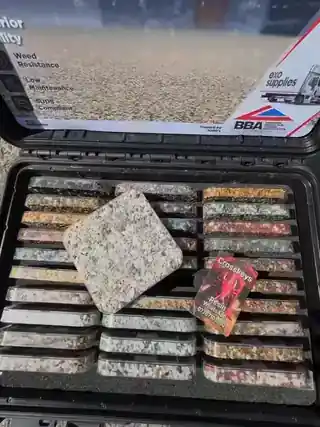 A hand choosing a resin sample from the sample case