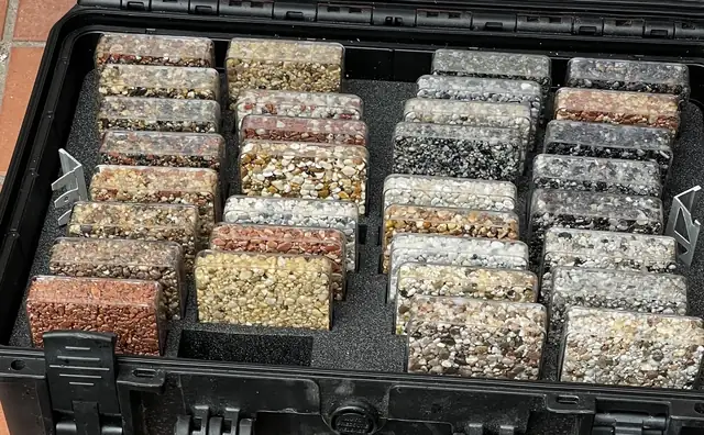 A sample case of resin bound blends, each one a clear box of loose stone in a foam tray