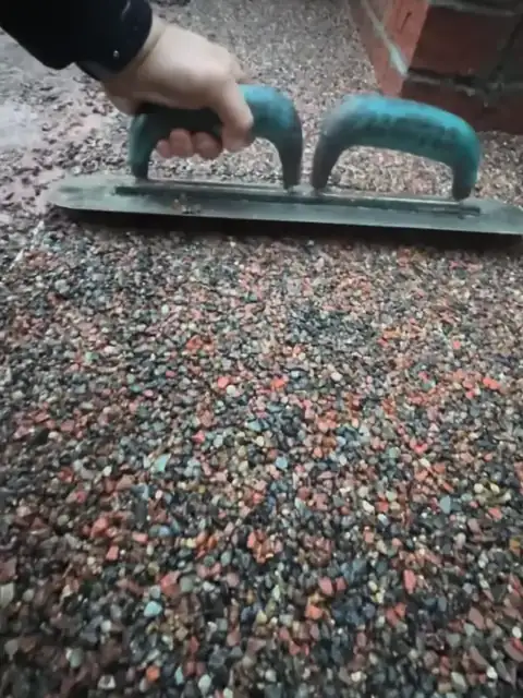 A trowel spreading terracotta resin bound stone