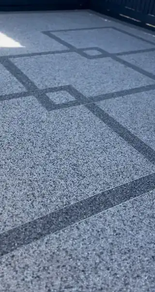 Close on grey resin bound surfacing meeting a block paved border