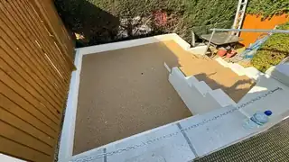 Golden resin being laid and levelled between timber edging boards