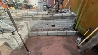 Groundwork in progress: a set of steps being formed against a timber fence