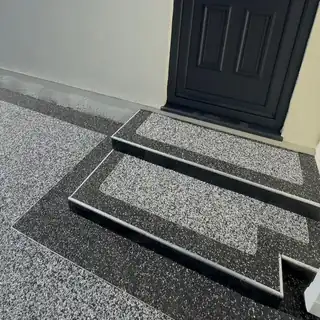 Silver-grey resin laid over a front doorstep and threshold, finished against a black border