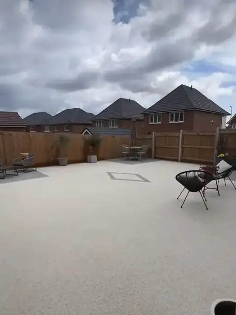 The finished cream resin patio with its grey diamond inlay under a cloudy sky