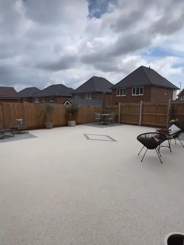 The finished cream resin patio with its grey diamond inlay under a cloudy sky