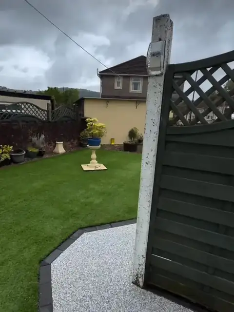 The new silver path running past a fence post into the garden