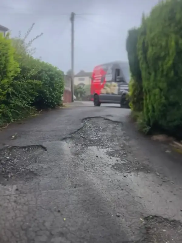 The old drive: broken, patched tarmac full of potholes
